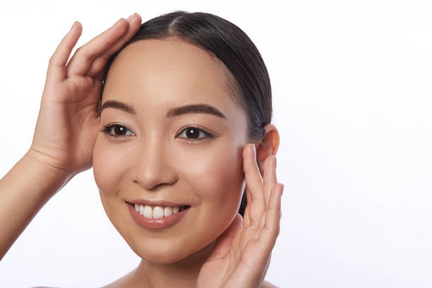 istock Cheerful young lady touching her face and looking happy 1151033689
