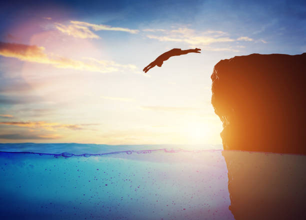 istock Man diving into water from high cliff to the unknown. 1151034406