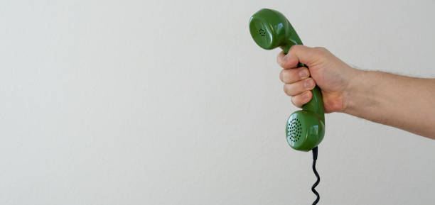 istock hand holding green telephone receiver 1151034750