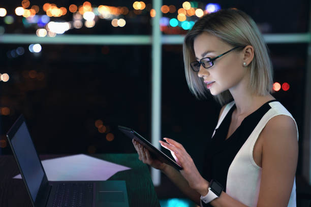 istock Beautiful female working late night in office with tablet 1151036645