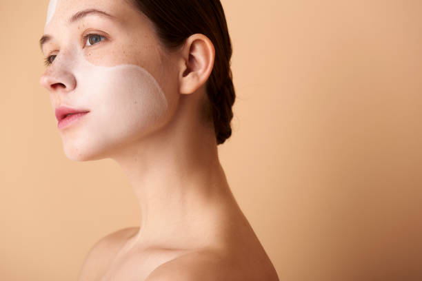 istock Charming lady with white mask on her face standing against beige background 1151043207