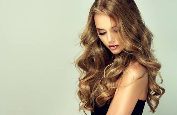 junge, frau mit tiefblondem, voluminösem und frizzy haar. ausgezeichnete haarwellen. friseurkunst und haarpflege. - fashion shiny blond hair hairstyle stock-fotos und bilder