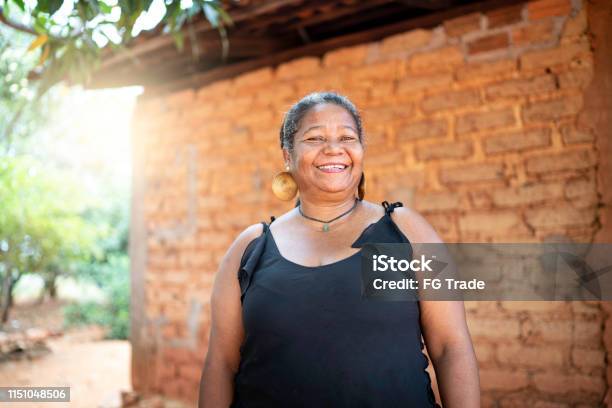 Portrait Of A Mature Woman In Front Of A Wattle And Daub House Stock Photo - Download Image Now