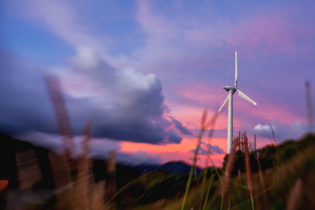 Gorgeous sunset on Kata beach view point. Electric wind turbine on pink cloudscape background. Phuket, Thailand. Shooted with Lens Baby Sweet 35mm with blurred zoom effect.