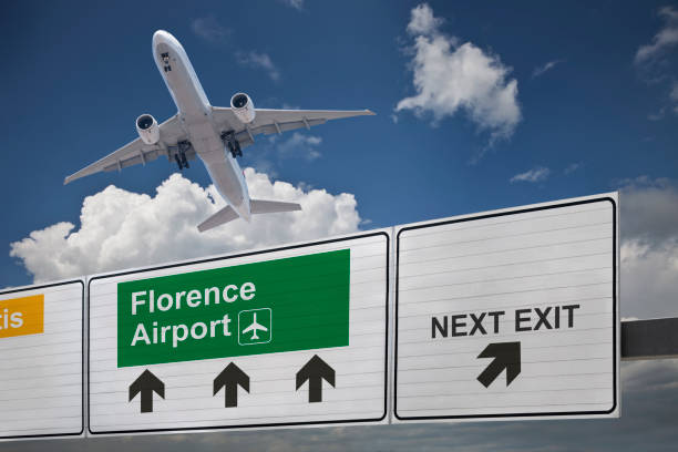 Road sign indicating the direction of Florense airport and a plane that just got up. Road sign indicating the direction of Florense airport and a plane that just got up. florence italy airport stock pictures, royalty-free photos & images