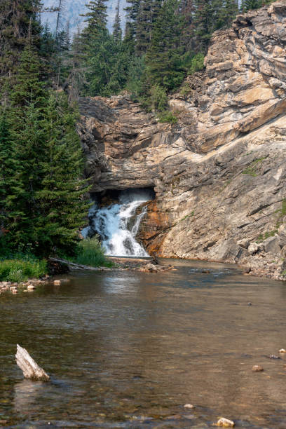 istock Running Eagle Falls emerges from a mountain in Glacier National Park 1151053677