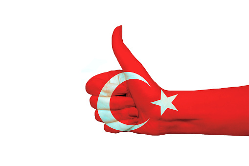 Turkey flag painted on hand showing thumbs up in isolated background