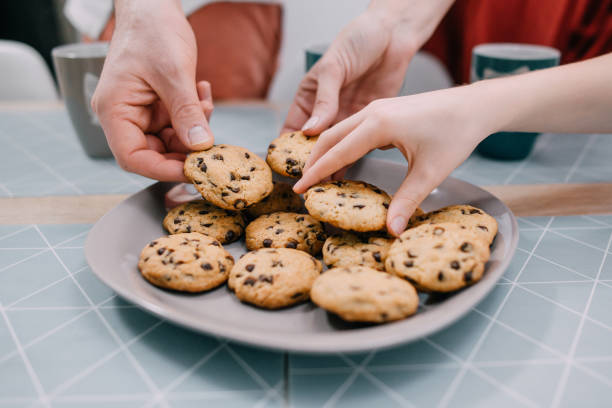 istock Hands take fresh cookies from plate, close-up 1151054250