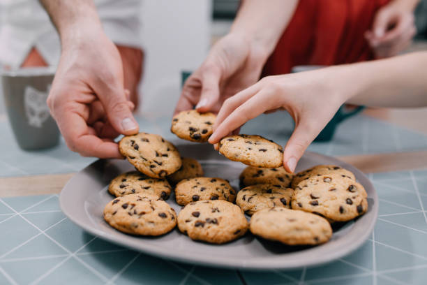 istock Hands take fresh cookies from plate, close-up 1151054265