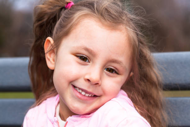 istock Four year old girl smiling outdoors 1151058085