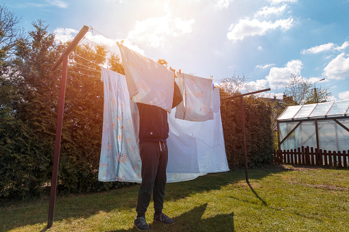 Man doing household chores and hanging the laundry