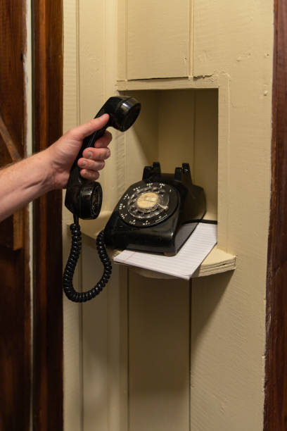 istock Hand using Old Rotary Phone sitting in nook in hallway 1151058871