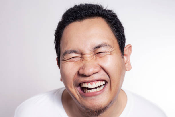 Photo image of funny cute Asian man smiling laughing, close up headshot portrait