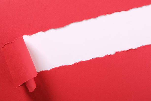 istock Torn red paper strip curled edge angled diagonal white background 1151061647
