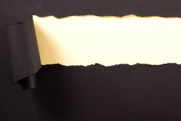 istock Torn black paper strip yellow background curled 1151062693