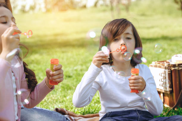 istock Kids together outdoors in the park weekend concept bubble blower close-up 1151067381