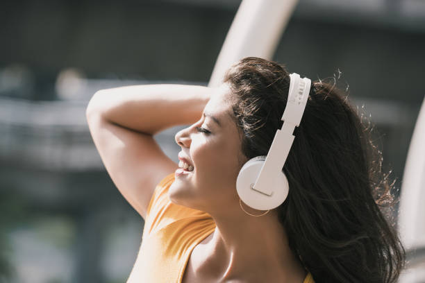 Happy Hispanic woman wearing headphones listening to music Young happy Hispanic woman wearing headphones listening to music with eyes closed free girl download stock pictures, royalty-free photos & images