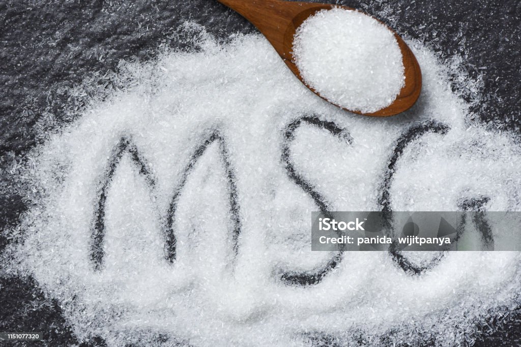 Tumpukan monosodium glutamat pada sendok kayu dan latar belakang gelap - teks MSG - Bebas Royalti Makanan - Makanan dan minuman Foto Stok