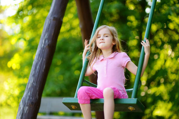 istock Adorable girl having fun on a swing 1151077414