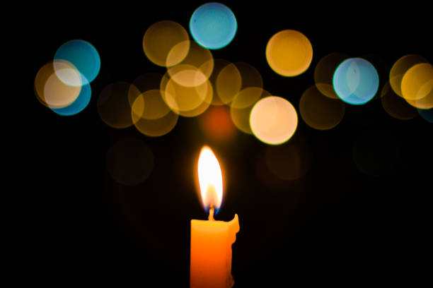 One candle flame light at night with bokeh background stock photo