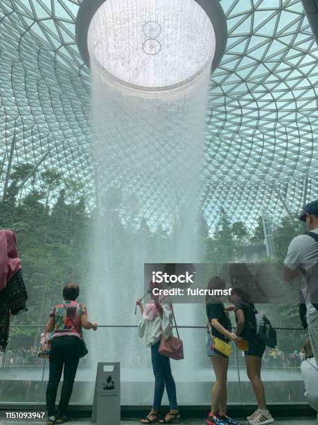 Singapore Singapore May 1 2019 Unidentified Women Takes A Selfie In Front Of The Rain Vortex Waterfall In Singapore Changi International Airport Other Unidentified People Are Also Pictured Stock Photo - Download Image Now