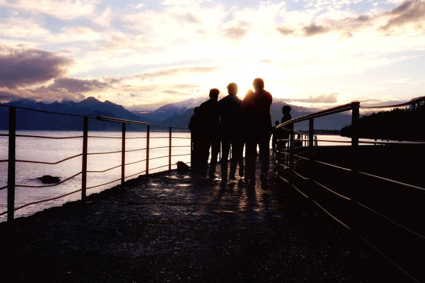 istock silhouetted people walking on street over sunset sky 1151094847