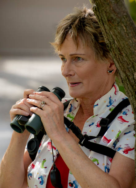 istock Mature woman bird watching with binoculars. 1151097903