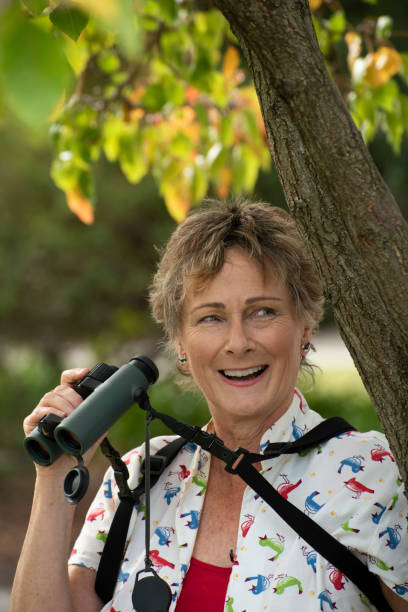 Mature woman bird watching with binoculars.