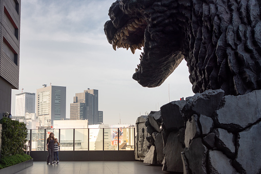 A mother and daughter staying at Hotel Gracery in Shinjuku, pose next to a full size Godzilla head located on the 8th floor. The modern 4 star hotel was recently constructed in 2015.