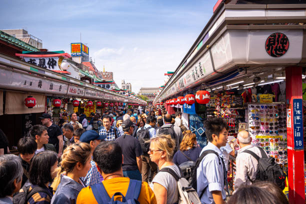 Touristen besuchen die Einkaufsstraße Nakamise, die zum Sensoji-Tempel in Asakusa, Tokio, Japan führt. – Foto