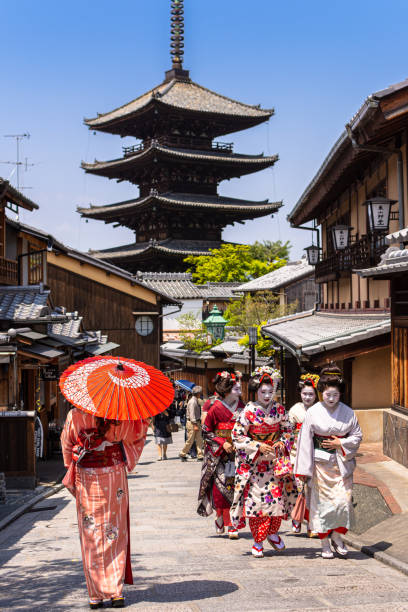 Grupo de geishas caminando en una calle cerca de la pagoda de Yasaka en Kioto, Japón - foto de stock