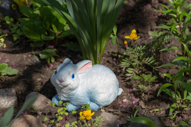 istock rabbit garden figurine under a bush 1151099792