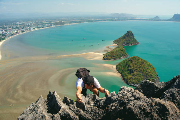 istock Portrait of strong athletic man climber making difficult move up on the multi-pitch at high altitude against scenic sea coast background. Climbing equipment. summer and vacation and hobby concept. 1151099954