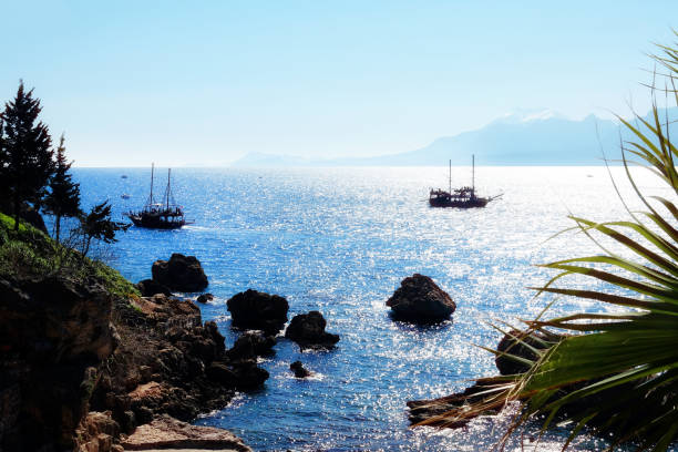 istock Mediterranean seascape image with palm tree and sailing tour boat 1151102790