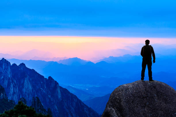 istock Young happy backpacker on top of a mountain enjoying valley view 1151103368