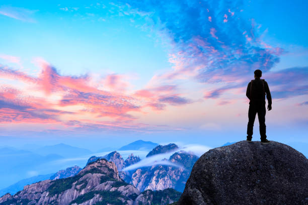 istock Young happy backpacker on top of a mountain enjoying valley view 1151103375