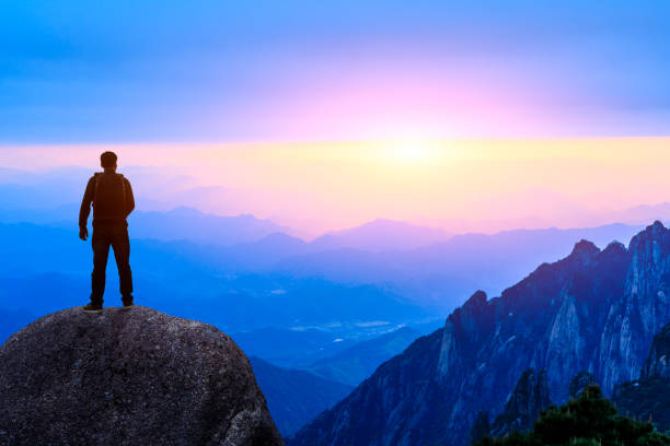 istock Young happy backpacker on top of a mountain enjoying valley view 1151103377