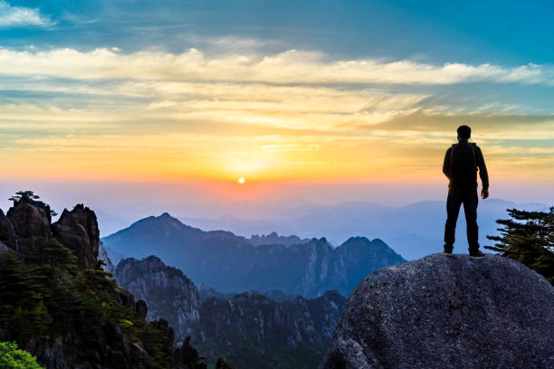 istock Young happy backpacker on top of a mountain enjoying valley view 1151103378
