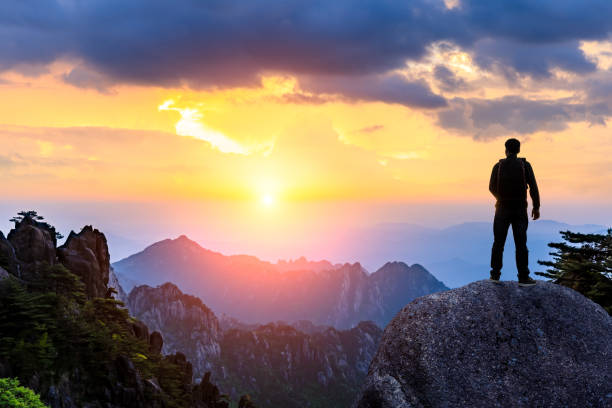 istock Young happy backpacker on top of a mountain enjoying valley view 1151103404