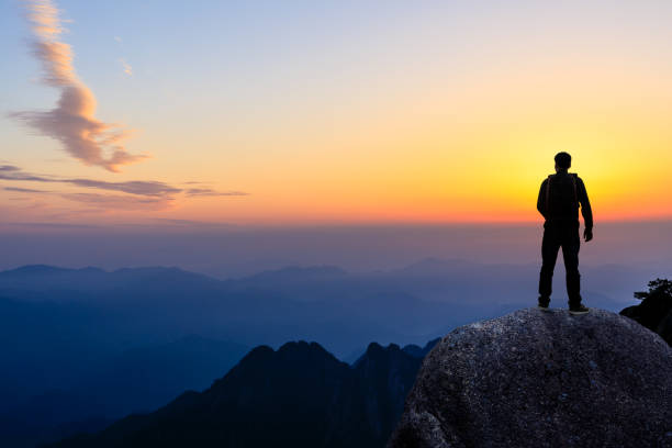istock Young happy backpacker on top of a mountain enjoying valley view 1151103462