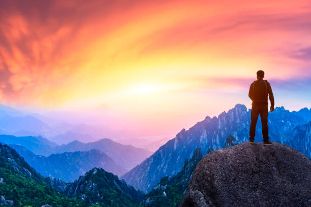 istock Young happy backpacker on top of a mountain enjoying valley view 1151103472