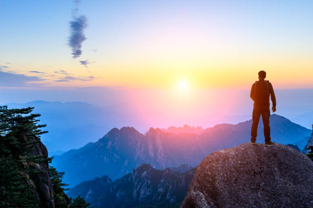 istock Young happy backpacker on top of a mountain enjoying valley view 1151103500