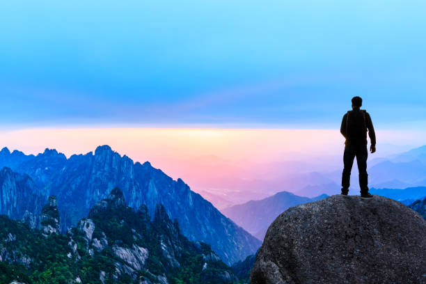 istock Young happy backpacker on top of a mountain enjoying valley view 1151103554