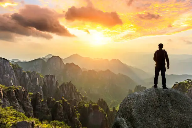 Young happy backpacker on top of a mountain enjoying valley view,travel concept scene