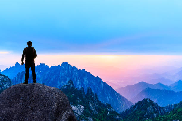 istock Young happy backpacker on top of a mountain enjoying valley view 1151103573