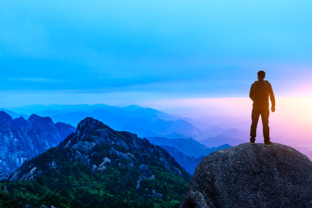 istock Young happy backpacker on top of a mountain enjoying valley view 1151103588