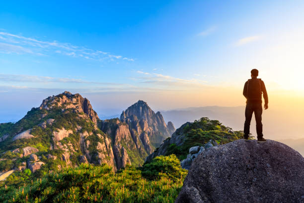 istock Young happy backpacker on top of a mountain enjoying valley view 1151103599