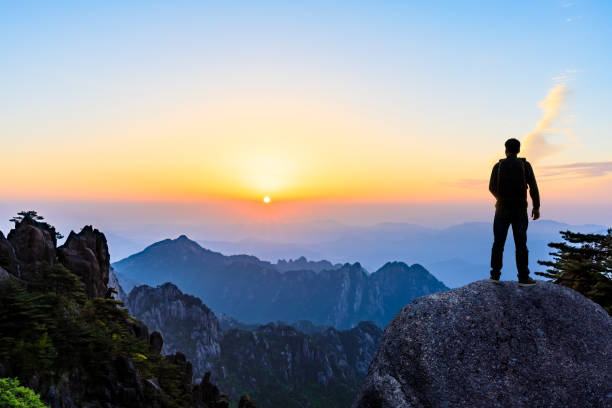 istock Young happy backpacker on top of a mountain enjoying valley view 1151103607