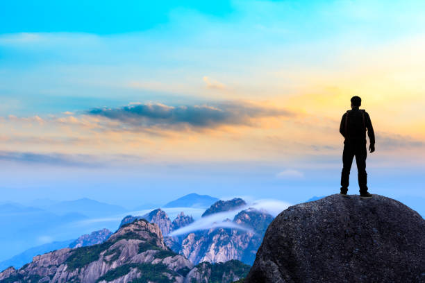 istock Young happy backpacker on top of a mountain enjoying valley view 1151103611