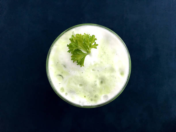 istock Ice green tea latte with milk top view on navy blue soft sofa background. 1151104656